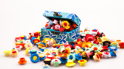 Fototapeta na wymiar Small, colorful paper flowers made with quilling technique and wooden painted box