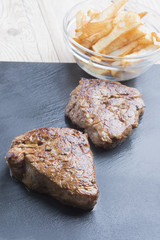 cooked beef chateaubriand steak with chunk chipped potatoes on p