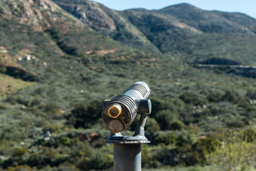 Viewing scope at lookout point overlooking mountain range. 