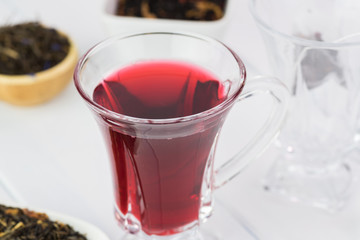 Glass tea cup with red hibiscus tea.