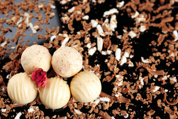 Assorted chocolate candies with flakes on black background