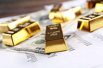 Gold bars with dollar banknotes on paper background