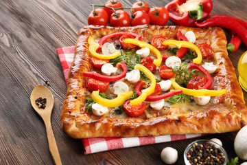 Freshly homemade pizza on wooden background