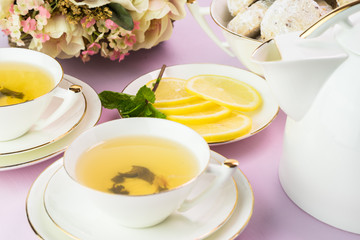 Tea cups with green tea and cookies.