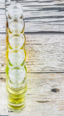 Avocado fruit oil, sesame seed oil, olive oil, grape seed oil and corn oil in vial glass bottle over rustic wooden background