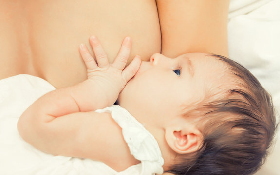 Soft focus image of newborn baby breastfeeding