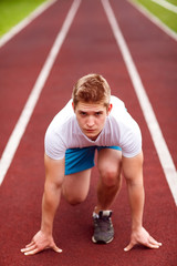 Obraz premium Beautiful athlete on a race track is ready to run