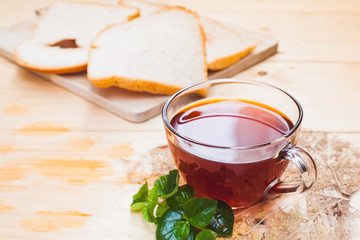 Cup of tea and bread on white wooden background