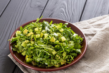 Beautiful Paleo Green Salad with Cucumber and Avocado on a Dark Grey Wooden Background, Horizontal
