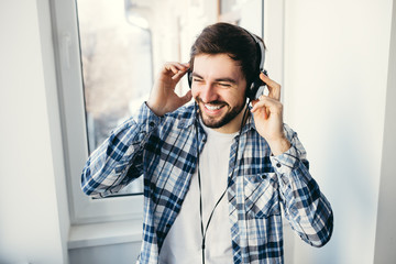Happy young man listens to music in headphones