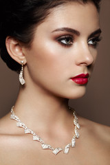 Fashion portrait of young beautiful woman with jewelry. Brunette girl. Perfect make-up.  Beauty style woman with diamond accessories