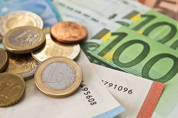 viele Eurogeldscheine und Münzen