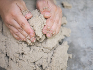Close up of kid's hands playing sand