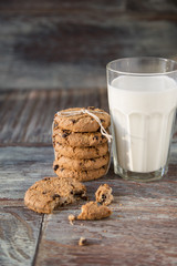 Tasty cookies and glass of milk on rustic wooden background