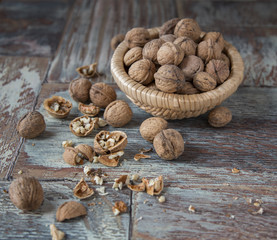 Walnut kernels and whole walnuts on rustic old wooden table