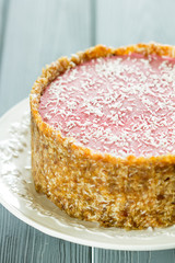 Raw Vegan Paleo Diet Berry Cheesecake Gluten-Free with Dates and Cashews on a Dark Grey Wooden Background, Vertical