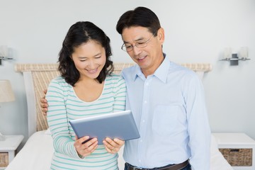 Obraz premium Happy couple using tablet