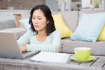 Serious brunette using laptop