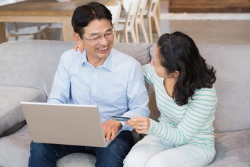 Happy couple using laptop