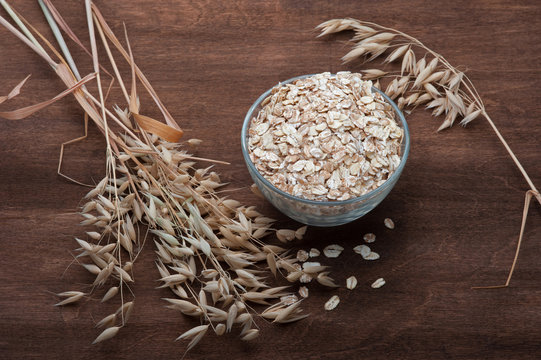 oatmeal with ears of oats on wooden dark background