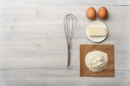 Top view of food ingredients on a white wooden background with copy space for recipe