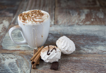 Hot coffee with marshmallows in a cup on the wooden background