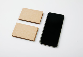 Two stack of craft business cards and black smartphone on white background. Horizontal