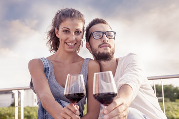 young couple farmers toasts in their vineyard
