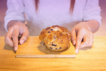 young woman holding banana muffins