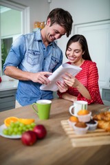 Obraz na płótnie Canvas Happy couple having breakfast and reading newspaper