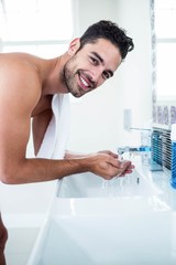 Man washing his face in sink