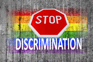 STOP sign and discrimination and LGBT flag painted on background