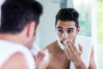 Handsome man shaving his beard