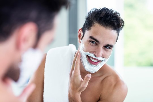 Handsome man shaving his beard
