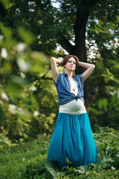Young Pregnant Woman in the Summer Park