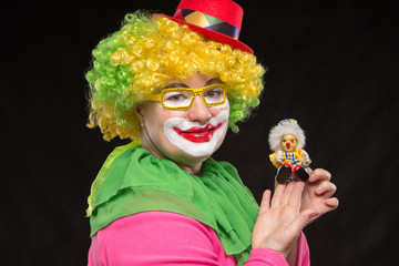 Good fun curly clown holding a beautiful little toy clown