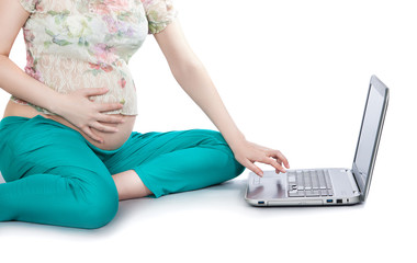 Fototapeta premium Pregnant woman working on laptop. Cropped image of pregnant wome