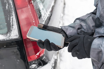 Driver calling with phone for help on the road in winter