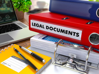 Red Ring Binder with Inscription Legal Documents on Background of Working Table with Office Supplies, Laptop, Reports. Toned Illustration. Business Concept on Blurred Background. 3d Render.