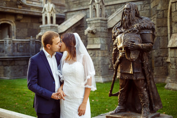 Portrait of beautiful wedding couple kissing at green lawn 