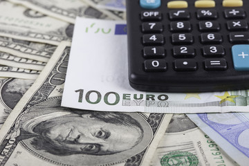 Fototapeta premium calculator and banknotes of dollars, euro background