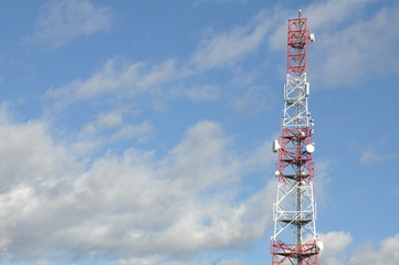 Telecommunication tower against cloudy sky