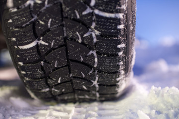 Closeup of winter tyre on the road, selective focus, shalow depth of field