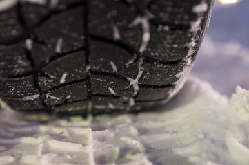 Closeup of winter tyre on the road, selective focus, shalow depth of field