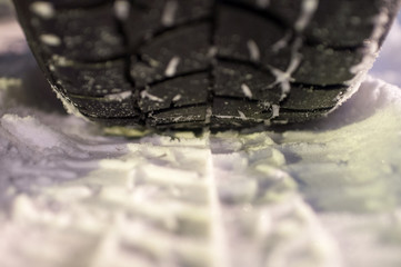Closeup of winter tyre on the road, selective focus, shalow depth of field