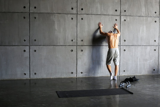 Man At The Wall In The Gym Resting After Exercise