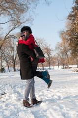 Young happy couple have fun on fresh snow at beautiful winter sunny day on vacation