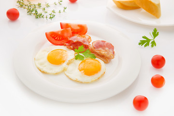 Traditional breakfast with bacon , fried eggs and bread