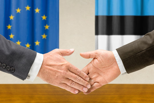Vertreter der EU und Estlands reichen sich die Hand