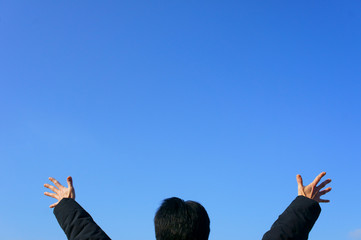 青空にバンザイする男性